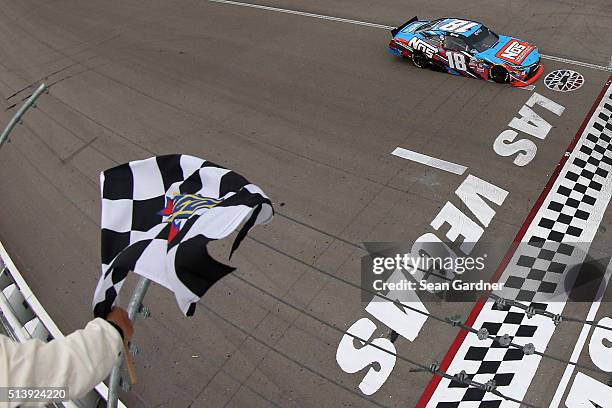 Kyle Busch, driver of the NOS Energy Drink Toyota, crosses the finish line to win the NASCAR Xfinity Series Boyd Gaming 300 at Las Vegas Motor...