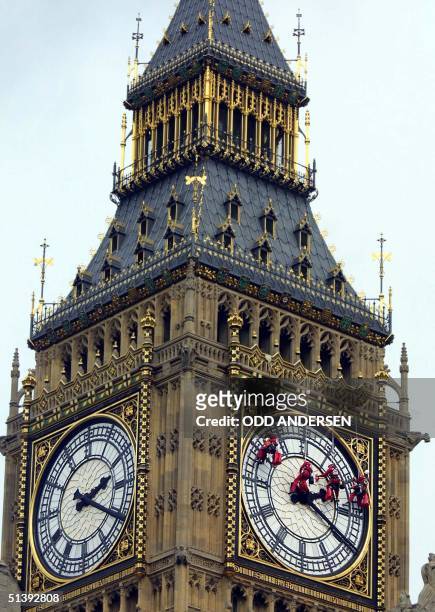 Workers hang from wires 20 August 2001 as they clean the London landmark clock tower Big Ben at the parliament in central London. AFP PHOTO / Odd...