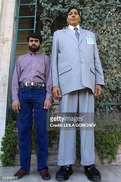 Twenty five-year old Pakistani Azad Khan Masood , 250cm tall, stands next to his brother, of average height, in Amman 13 September 2001. Masood, who...