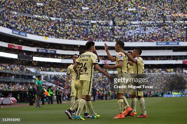 Oribe Peralta of America celebrates with teammates after scoring the first goal of his team during the 9th round match between America and Morelia as...