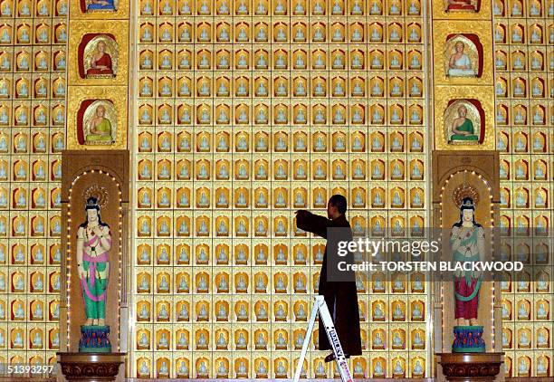 Reverend Man Chu checks 8,000 individually lit statues of Buddha in the Great Hero Hall of the Nan Tien Temple in Wollengong near Sydney 05 October...
