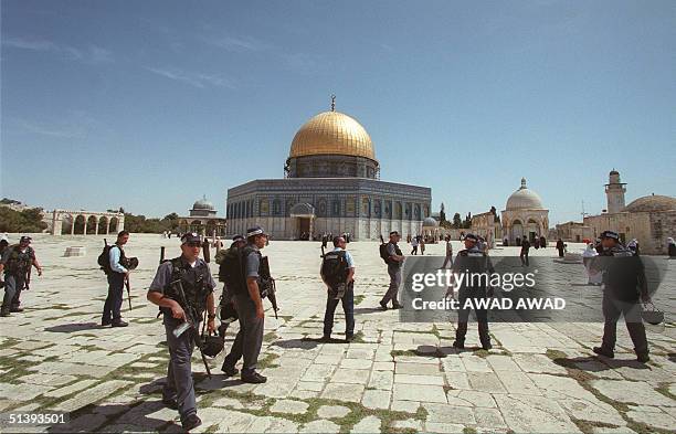 Israeli policemen walk in front of the Dome of the Rock inside the Al-Aqsa Mosque compound in Jerusalem's Old City 20 April 2001, in an attempt to...