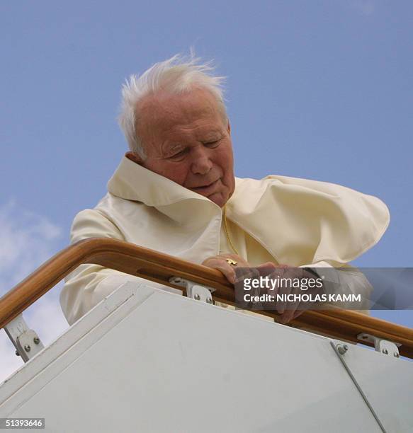 Pope John Paul II leans on the bannister of the gangway of his plane at Damascus airport 08 May 2001 before departing for Malta on the last leg of...