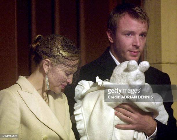 Pop singer Madonna looks down at her son Rocco held by film director Guy Ritchie as they leave Dornoch Cathedral 21 December 2000. The couple...