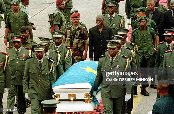 Laurent-Desire Kabila's coffin is carried by Congolese officers 21 January 2001 upon it's arrival from Lumumbashi at n'Djili airport in Kinshasa....