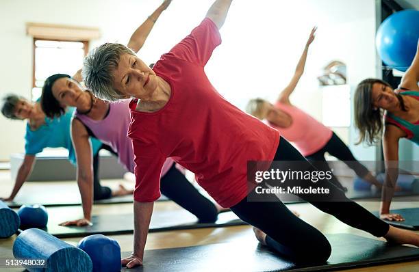 staying supple in her senior years with pilates - plank exercise stockfoto's en -beelden