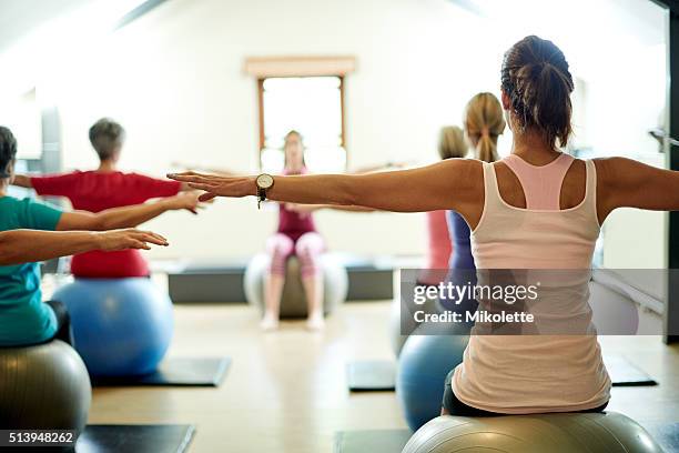 stretching their way to a stress free life - yoga ball stock pictures, royalty-free photos & images