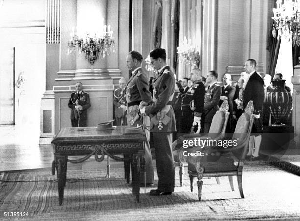 King Leopold III of Belgium speaks during the abdication ceremony, 16 July 1951 in the Royal Palace of Brussels, as his son listens. His son becomes...