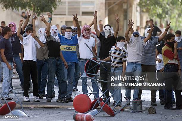 Masked Arab Israeli youths gesture the V-sign during a demonstration in the northern Israeli town of Nazareth 03 October 2000. Clashes erupted again...