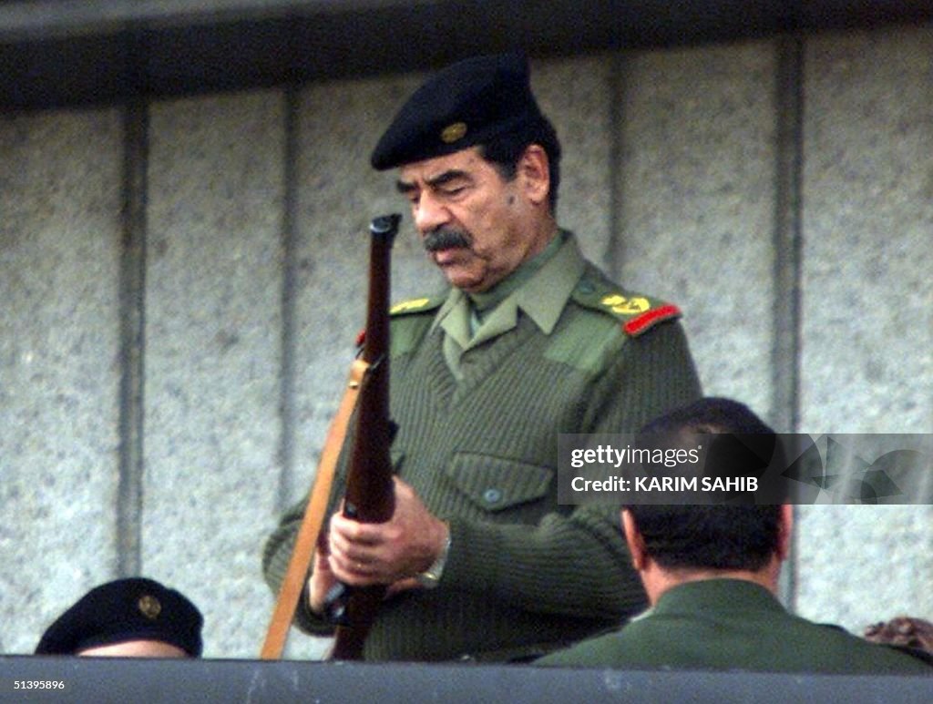 Iraqi President Saddam Hussein prepares his gun to