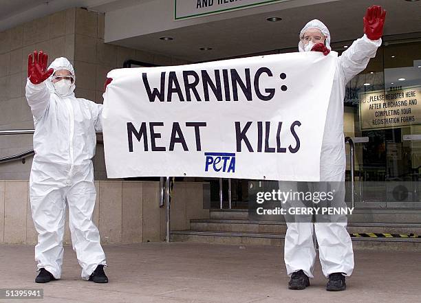 Protesters from PETA, People for the Ethical Treatment of Animals, try to stop the public from entering the Smithfield 2000 agriculture exhibition at...