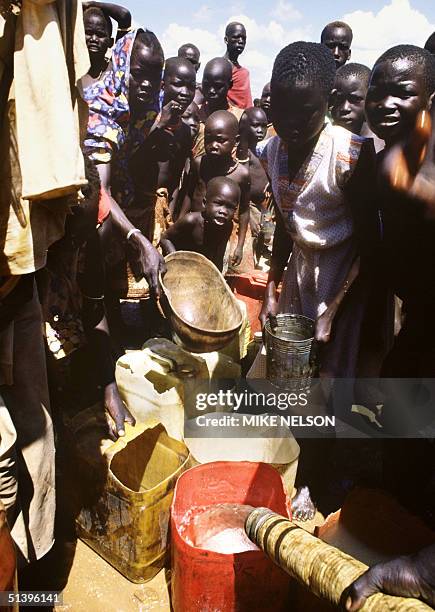 Children belonging to Mundari displaced ethnic group, wait for the water supply in September 1986 in a UNHCR refugee camp outside Juba, the capital...