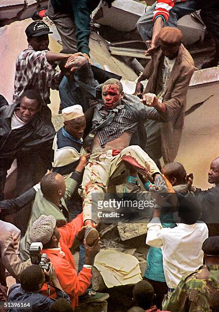 People help rescue one of the people injured when a bomb exploded near the US embassy and a bank in Nairobi 07 August 1998, killing at least 60...