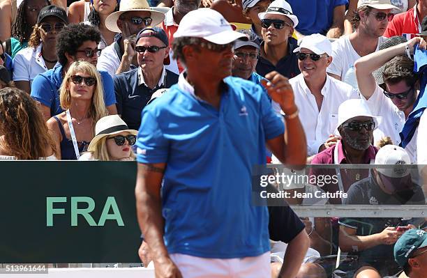 Isabelle Camus, wife of Yannick Noah and Zacharie Noah, his father look on while Yannick Noah stands on the court as captain of Team France during...