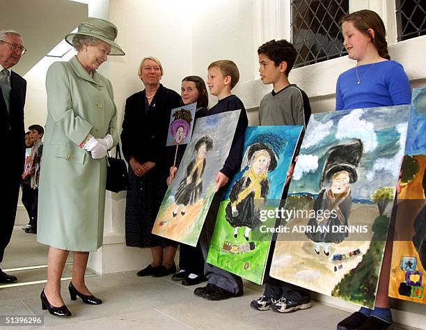 Britain's Queen Elizabeth is introduced to schoolchildren with their paintings of "Queen Victoria aged four", copies of the famous painting by S.P...