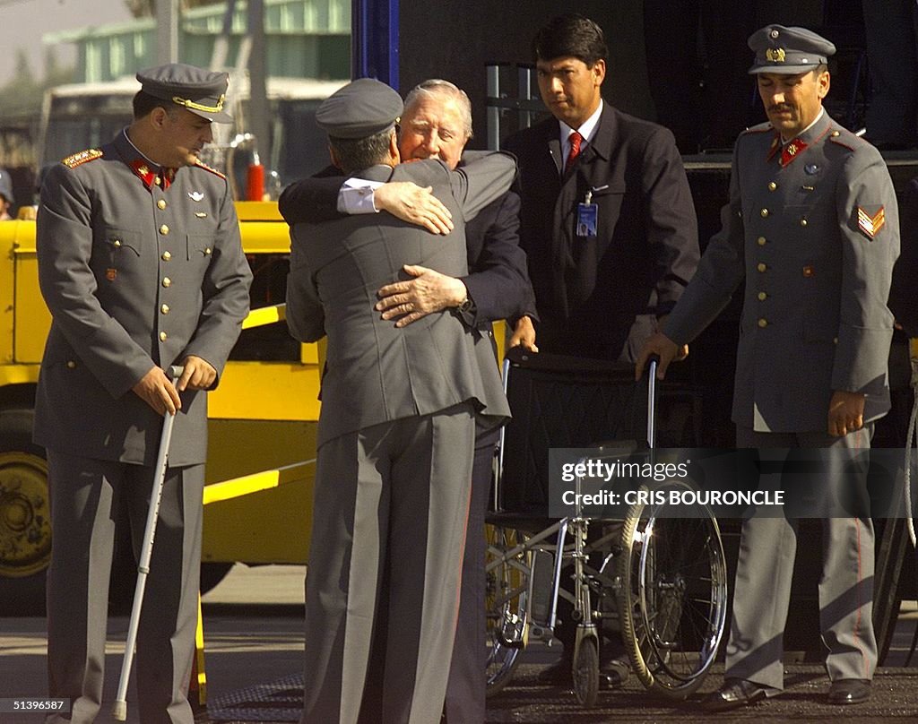 Chilean ex-dictator Augusto Pinochet embraces a co
