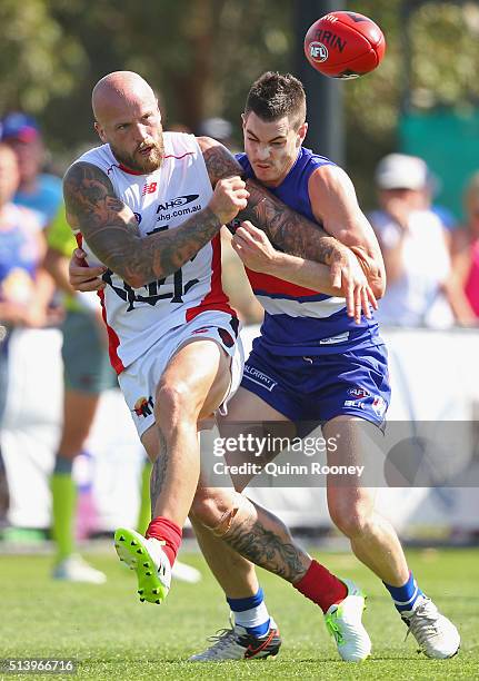 Nathan Jones of the Demons handballs whilst being tackled during the 2016 AFL NAB Challenge match between the Western Bulldogs and the Melbourne...