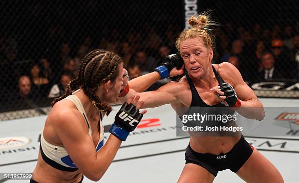 Miesha Tate punches Holly Holm in their UFC women's bantamweight championship bout during the UFC 196 event inside MGM Grand Garden Arena on March 5,...