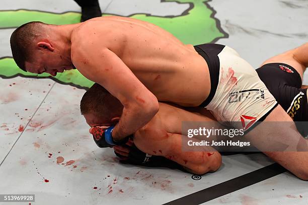 Nate Diaz punches Conor McGregor of Ireland in their welterweight bout during the UFC 196 event inside MGM Grand Garden Arena on March 5, 2016 in Las...