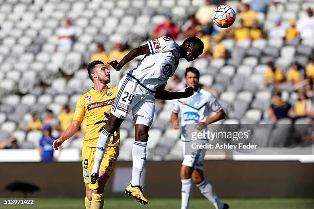 Thomas Deng of the Victory heads the ball ahead of Roy O'Donovan of the Marines during the round 22 A-League match between the Central Coast Mariners...