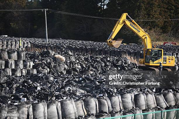 Radiation contaminated debris and soil is stockpiled for disposal near the Tokyo Electric Power Co.'s embattled Fukushima Daiichi nuclear power plant...