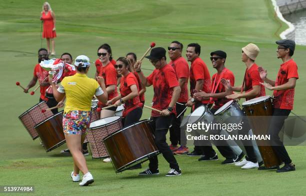 South Korea's Jang Ha-Na holds her trophy and dances to the music after winning the final round of the HSBC Women's Champions golf tournament at the...