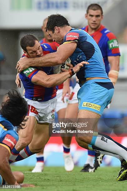 Jarrod Mullen of the Knights is tackled by David Shillington of the Titans during the round one NRL match between the Gold Coast Titans and the...