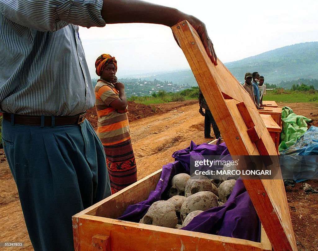 People look at unearth remains from a mass grave i