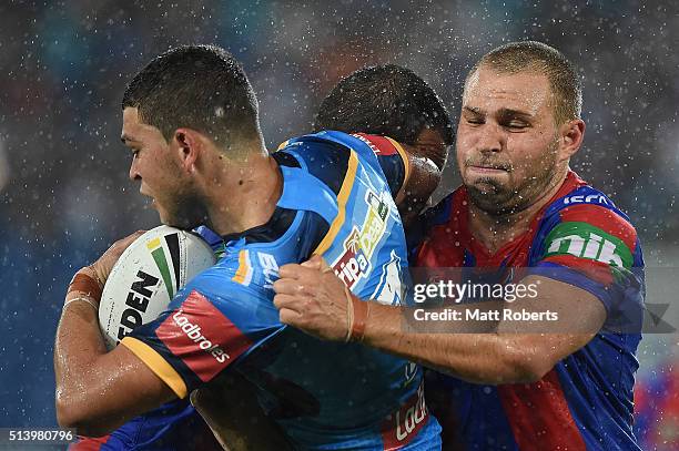 Ash Taylor of the Titans is tackled by Robbie Rochow of the Knights during the round one NRL match between the Gold Coast Titans and the Newcastle...