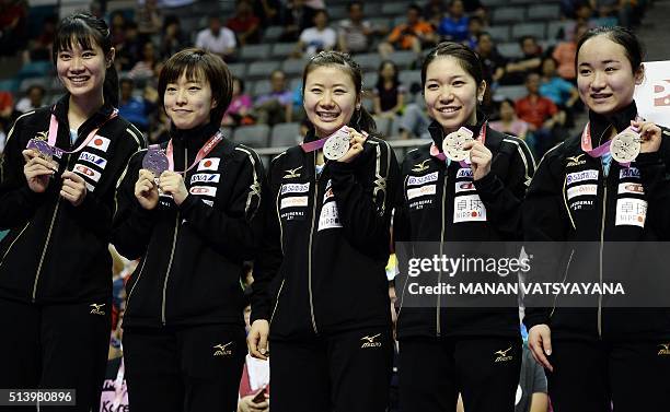 Japanese table tennis team players Yui Hamamoto, Kasumi Ishikawa, Ai Fukuhara, Misako Wakamiya and Mima Ito pose on the podium after finishing in...