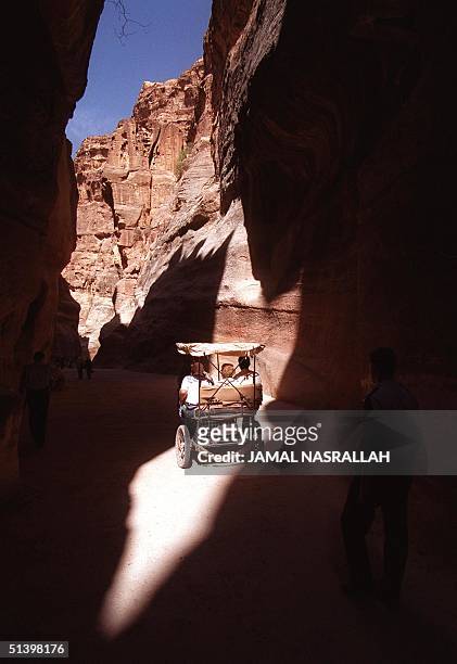 Visitors to the ancient Nabatean 'rose city' of Petra ride, 08 November 1999, a horse-drawn carriage through the 'siq', a two-kilometer downhill...