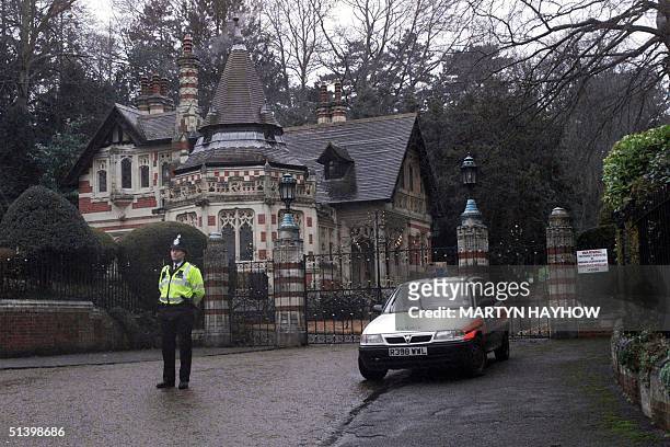 Police officer stands outside the Lodge gates of George Harrison's Friar Park property at Henley, 30 December1999. The former "Beatle" was taken to...