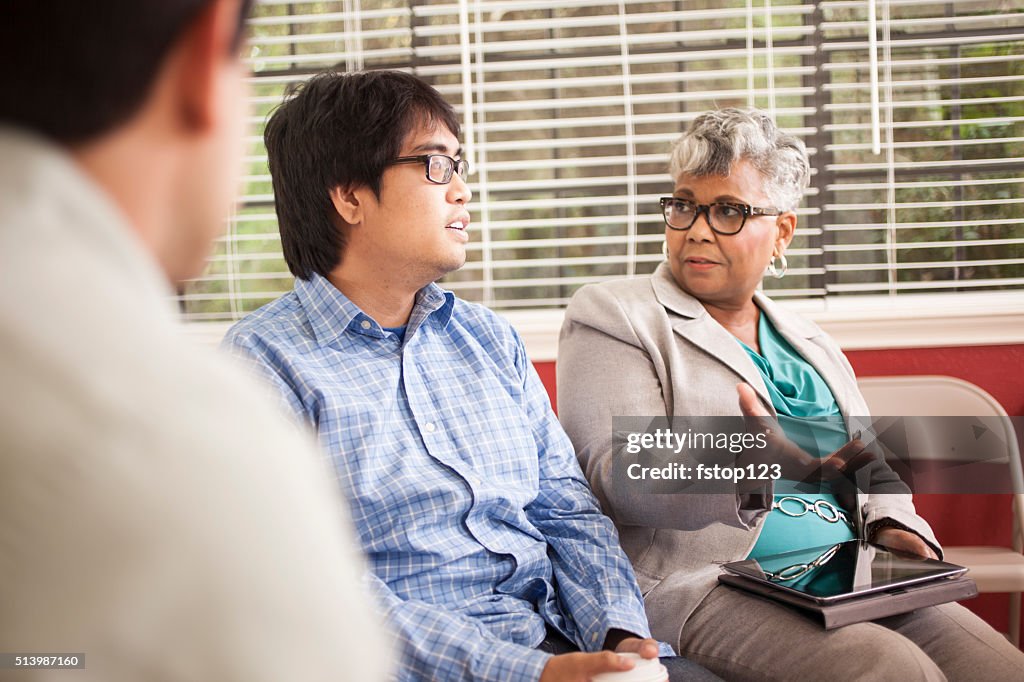 Multi-ethnic group of people in counseling session with therapist.