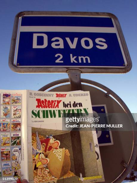 An issue of a world-known French comics entitled " Asterix with the Swiss " by Rene Goscinny and Albert Uderzo hangs by a steetsign pointing at Davos...
