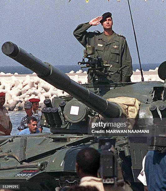 Libyan leader Moamer Khadhafi's eldest son Saif al-Islam salutes from a Russian made tank 07 September 1999 during a military parade in Tripoli to...