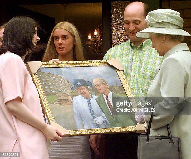 The Queen Elizabeth II receives a painting recording her visit with the Duke of Edinburgh to the St. Andrews Gardens Estate in Liverpool Thursday 22...