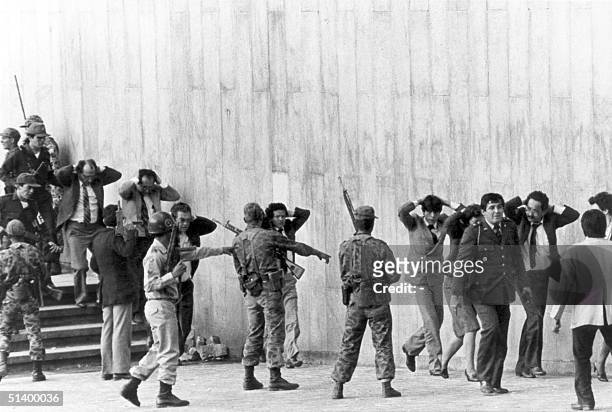 Colombian army troopers protect a group of justices coming out of the Palace of Justice in Bogota, occupied 06 November 1985 by a M19 movement...