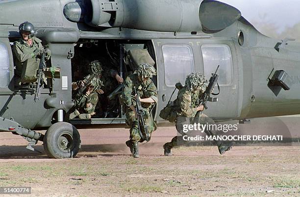 Soldiers run for cover following their arrival at a military command post loyal to General Manuel Antonio Noriega 23 December 1989 in Santiago 200...