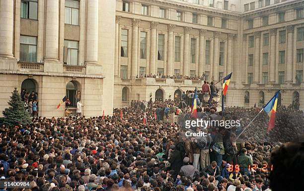 Some Bucharest citizens wave Romanian flags amongst thousands as they stage an anti-communist demonstration at the Republic Square, 21 December 1989...
