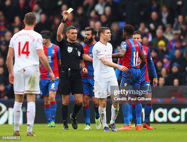 James Milner of Liverpool is shown a second yellow card by referee Andre Marriner and is sent off during the Barclays Premier League match between...