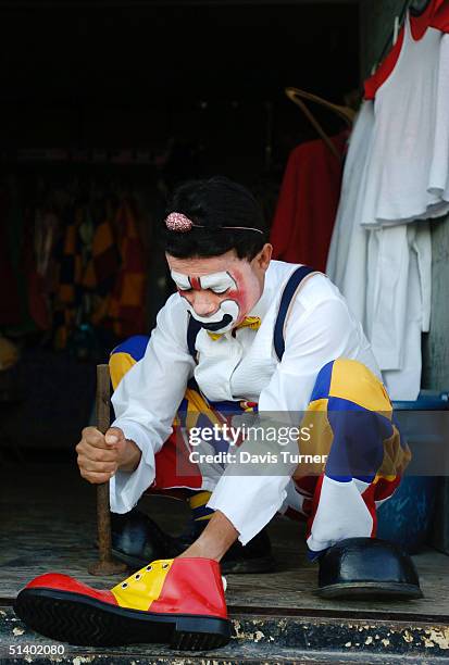 Clown Jair "Perrolito" Bermudez repairs a shoe in the costume trailer between shows with the Cole Brothers Circus October 4, 2004 in Gastonia, North...