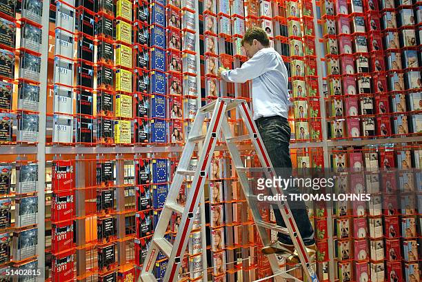 Germany: A Publisher's associate stands on a ladder as he fills a huge shelf with books, 05 October 2004 ahead of the 56th edition of the Frankfurt...