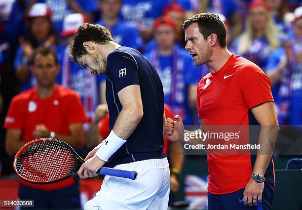 Andy Murray of Great Britain is urged on by Leon Smith the Great Britain team captain during the singles match against Kei Nishikori of Japan on day...