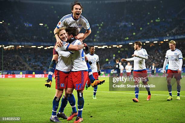 Nicolai Müller of Hamburg celebrates scoring his second goal with Albin Ekdal and Lewis Holtby during the Bundesliga match between Hamburger SV and...