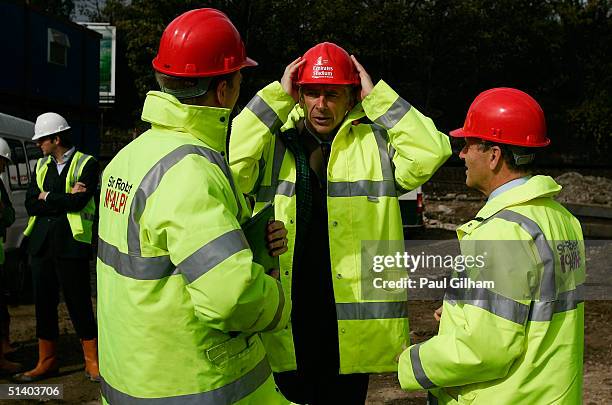 Manager Arsene Wenger of Arsenal puts his hard hat on outside Arsenal Football Club's new Emirates Stadium development at Ashburton Grove on October...