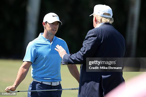 Republican presidential candidate Donald Trump makes an appearance prior to the start of play and speaks with golfer Rory McIlroy of Northern Ireland...