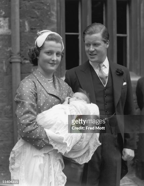 Viscount Althorp with his wife Hon Frances Roche with their baby daughter Sarah, sister of Lady Diana Spencer, after her christening at Westminster...