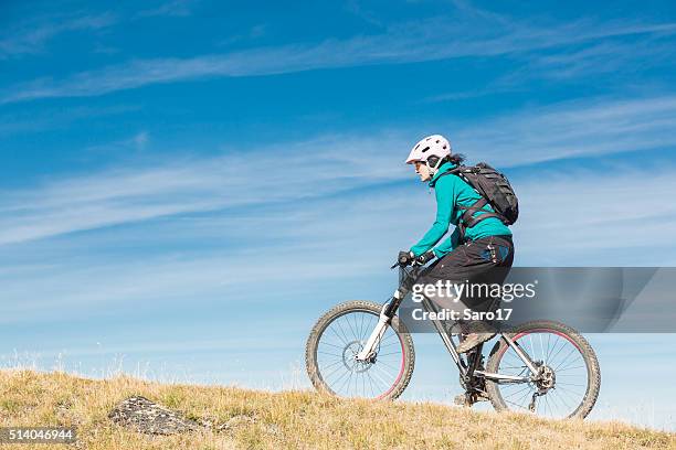 female mountainbiker uphill, switzerland - uphill stockfoto's en -beelden