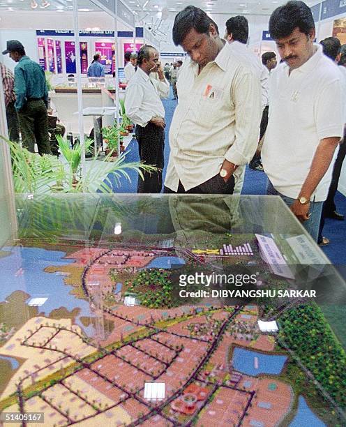 Two software professionals look at a model of the new software park in Madras 14 September 2001 during an Information Technology, Communication...