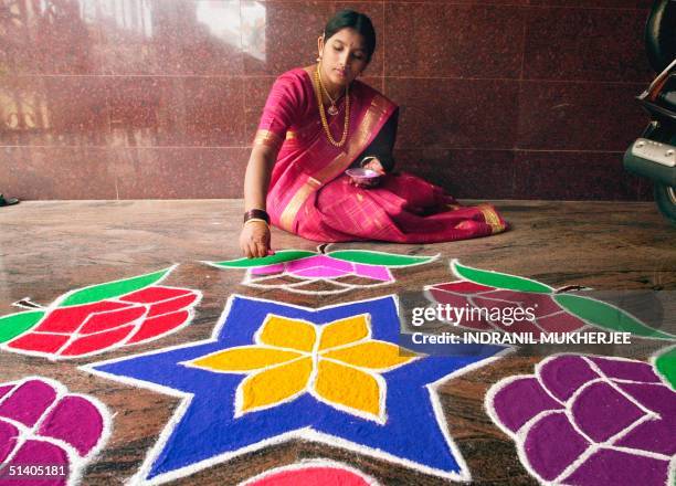 Padma gives finishes touches to a "rangoli", a coloured powder decoration, to celebrate the Diwali festival at her home in Bangalore, 14 November...